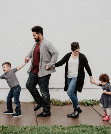 Four people family holding hands and going in a line.