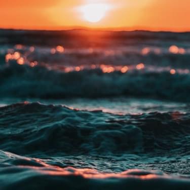 Ocean waves and sun in sunset.